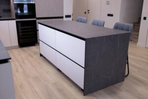 Weiße Mattküche Zürich — Kochinsel mit Waterfall-Keramikplatte und Weinkühlschrank