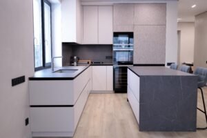 Weiße Mattküche Zürich — Gesamtansicht mit Keramik-Kochinsel und Eichen-Hochschränken